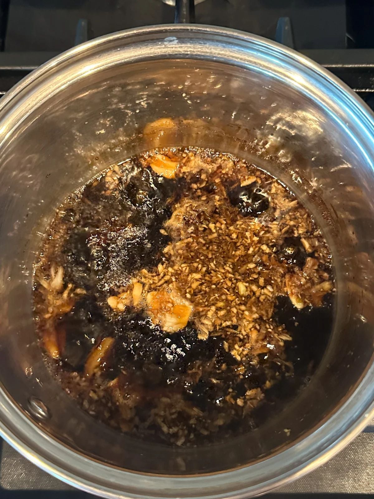 Cooking marinade in a pot with garlic, ginger and soy sauce.