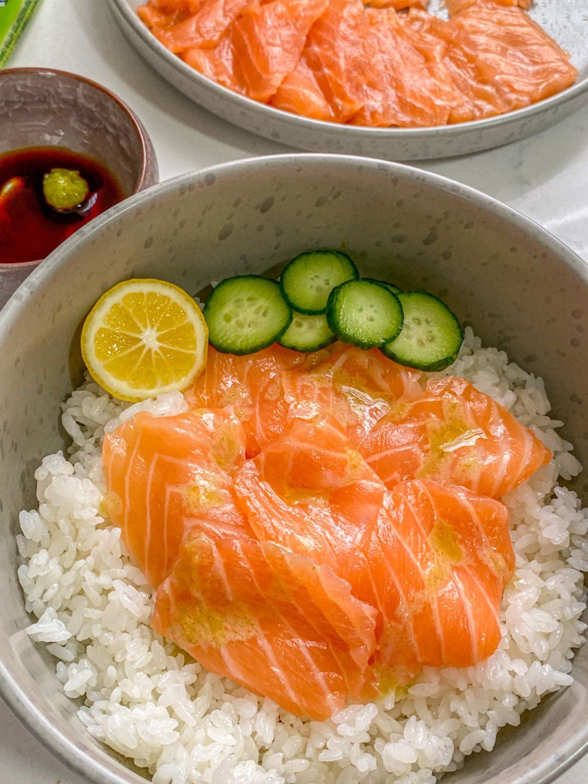 salmon sashimi or sushi grade salmon sliced thin with rice, cucumbers, soy sauce and wasabi.