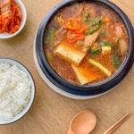 Doenjang jjigae fermented soybean paste stew with white rice, kimchi and spoon