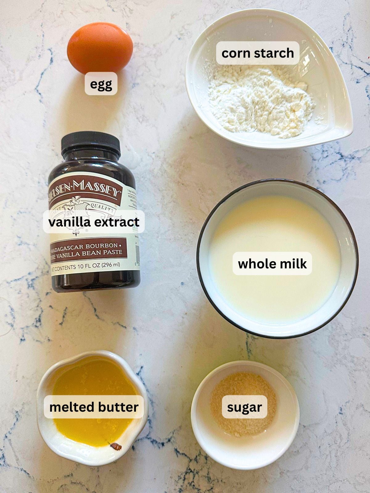 Ingredients laid out for the custard filling including egg, corn starch, vanilla extract, whole milk, melted butter and sugar.