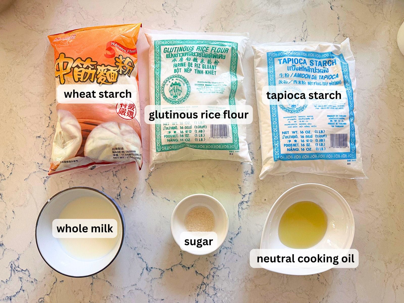 Ingredients laid out for the snow skin (mochi) filling including wheat starch, glutinous rice flour, tapioca starch, whole milk, cooking oil and sugar.