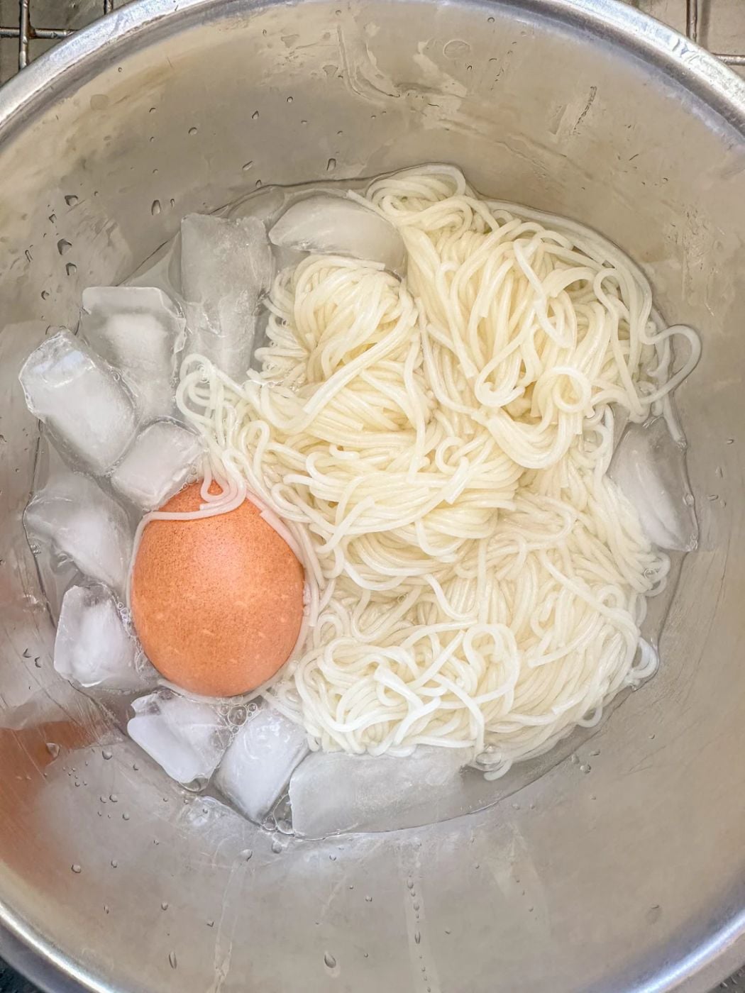 White noodles and egg in an ice bath.