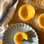 chinese egg tarts on a plate on and on a wire rack cooling down