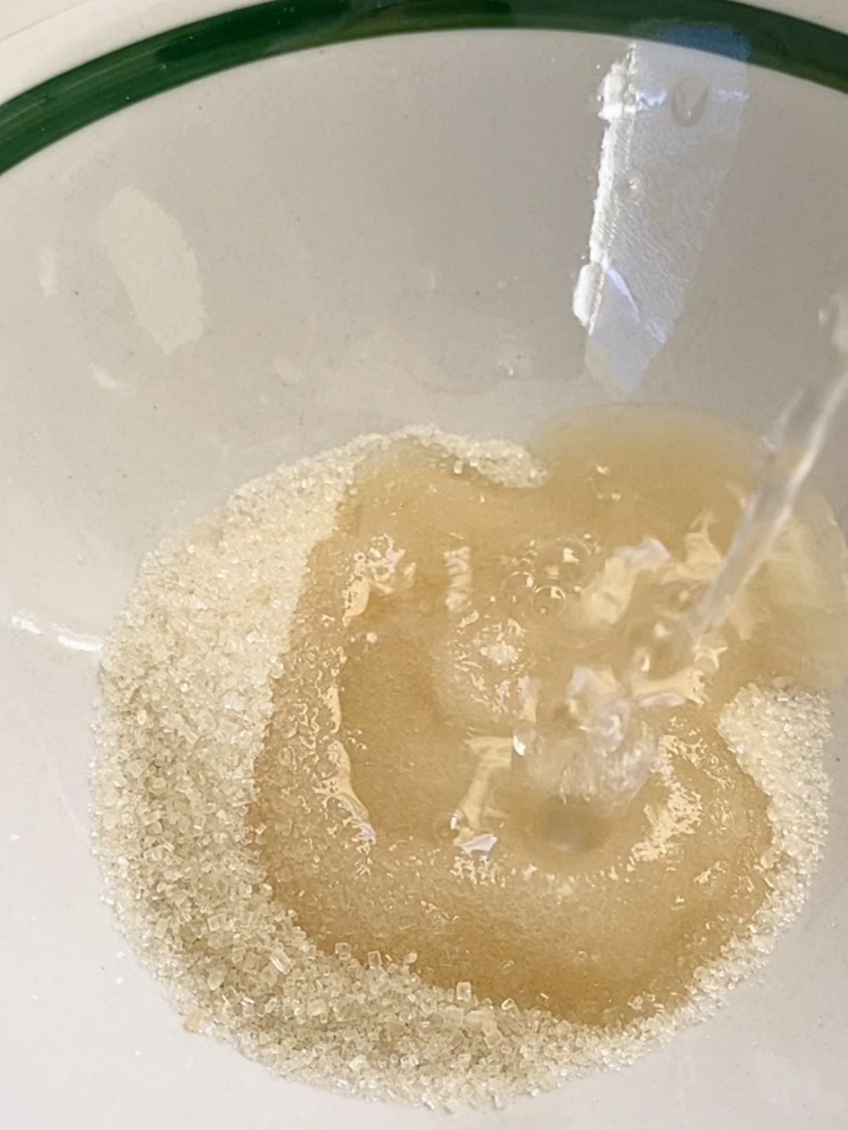 Adding some warm water to a bowl of sugar.