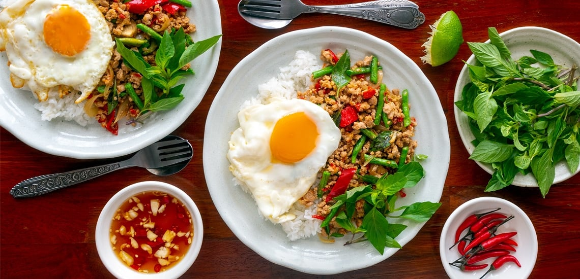 pad kra pow dish with a fried egg and served with chilis and fish sauce basil rice