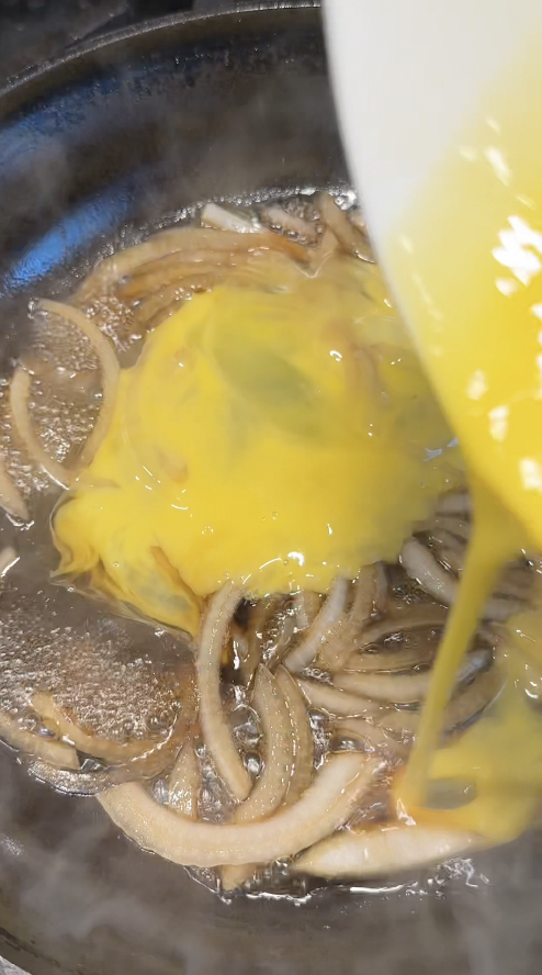 adding beaten eggs in onions and soy