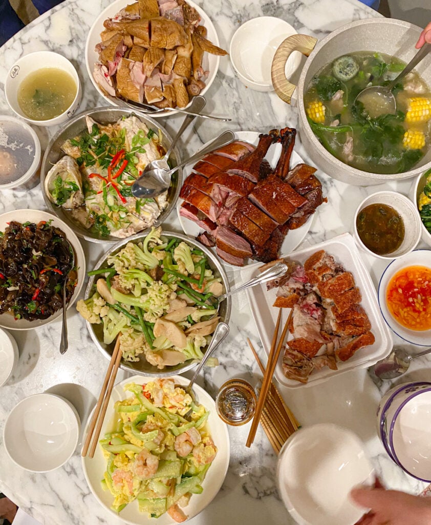 lots of dishes on the table such as scrambled egg, duck, soup, roast pork