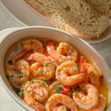 Shrimp with chopped parsley in olive oil served with sourdough bread.