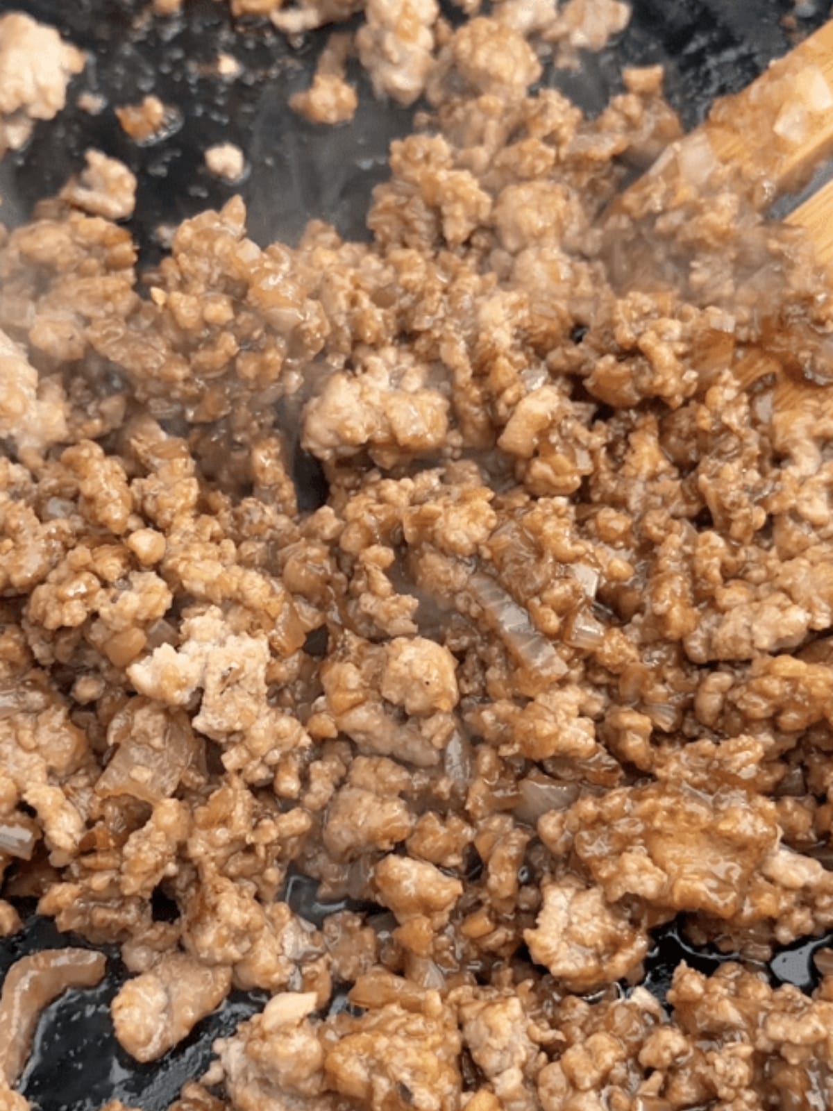 Cooked ground pork in pan.