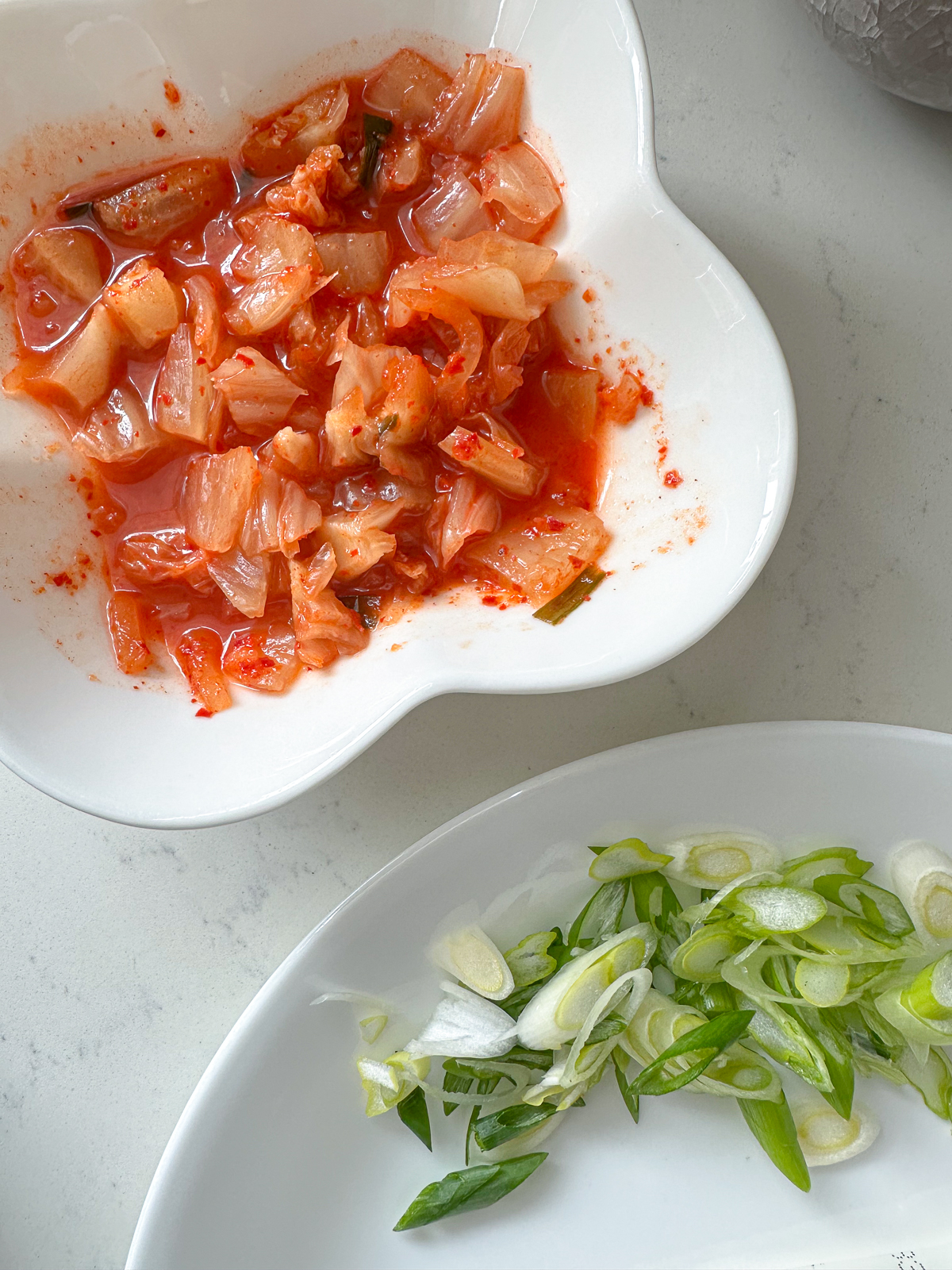 Cut kimchi and sliced green onions in a bowl.