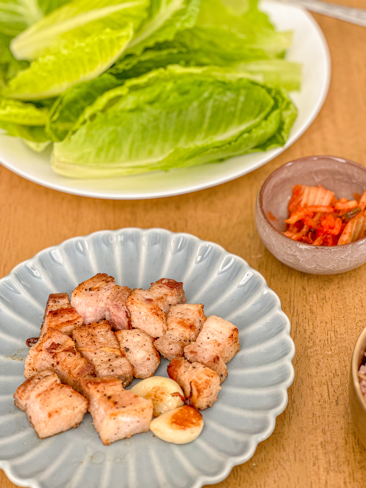 Grilled pork belly with lettuce and kimchi on the side.