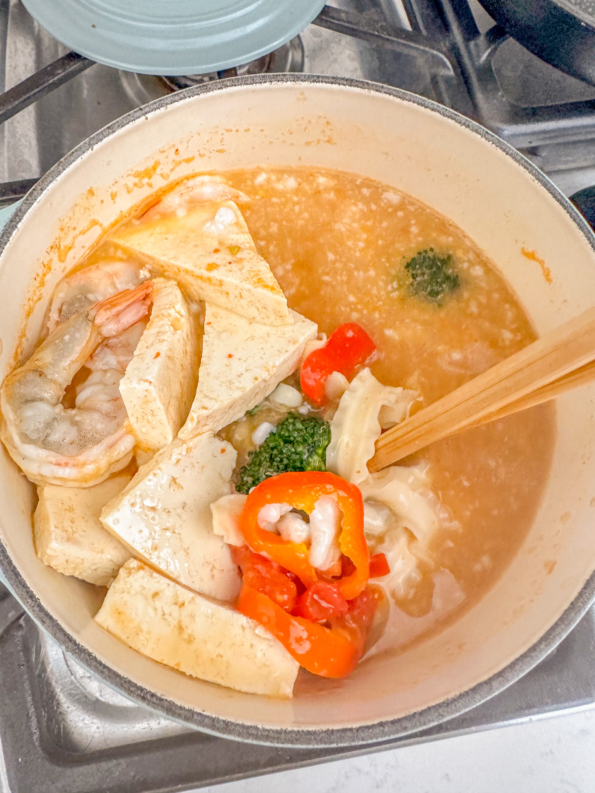 Stirring noodles with shrimp, tofu and bell peppers.