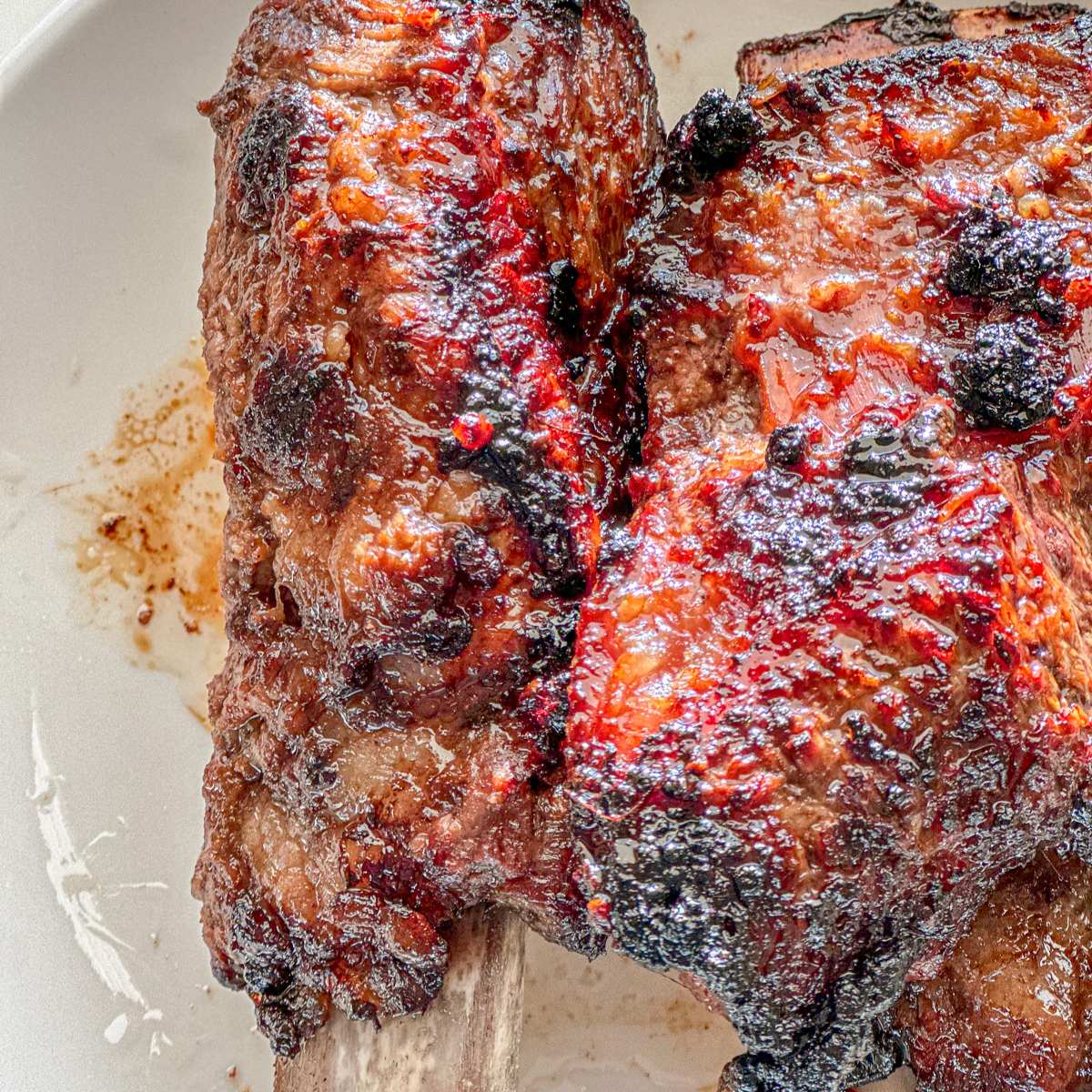 Charred Korean beef short ribs on a white plate.