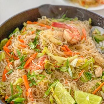 Noodles with celery, carrot, cabbage, onion, shrimp and pork in a pan.