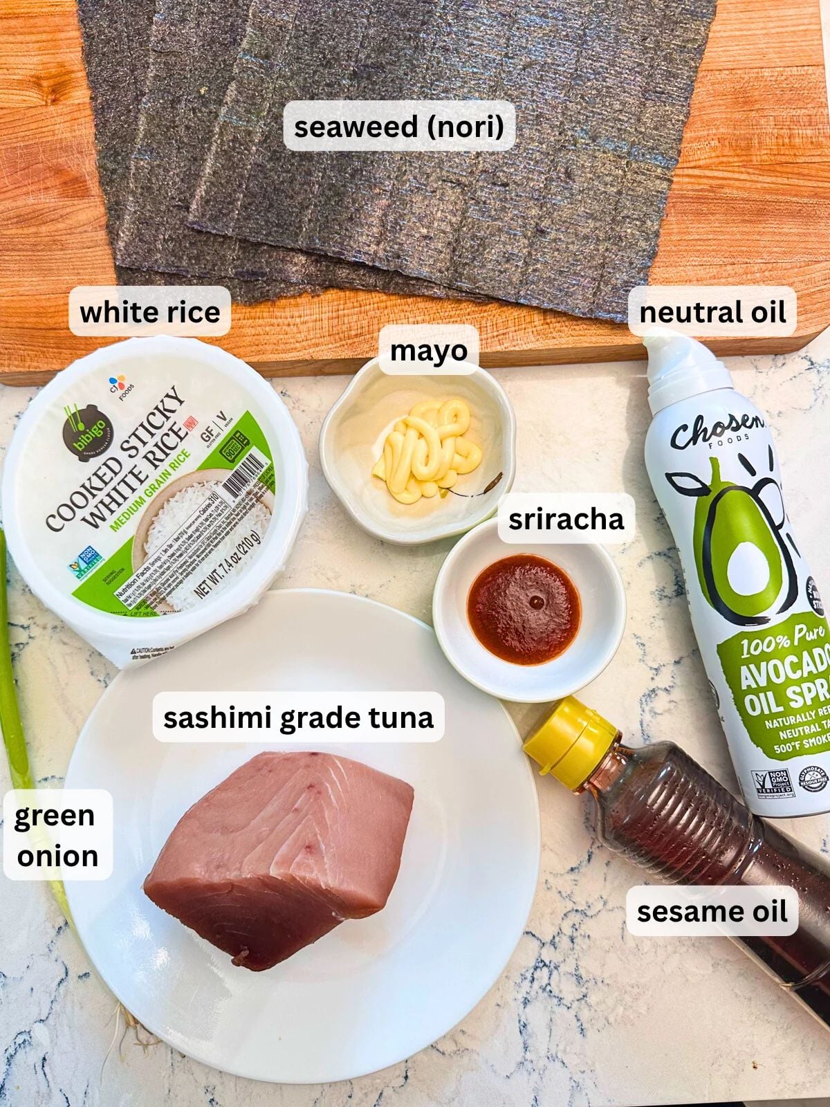 Labeled ingredients for Tuna Poke Tacos, including seaweed nori, cooked white rice, mayo, sriracha, neutrail oil, sesame oil, green onion, and sashimi grade tuna.