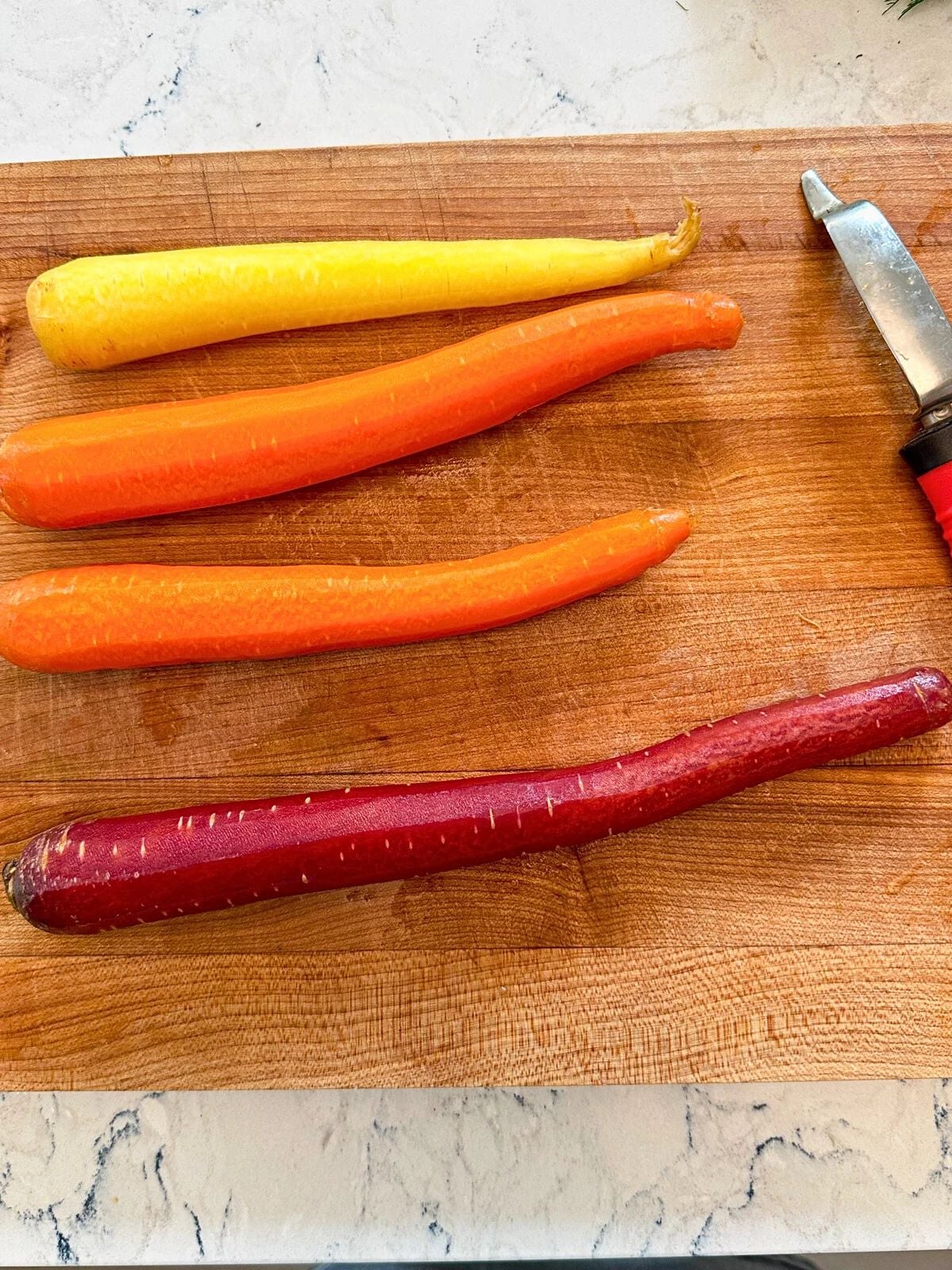 Washed and peeled carrots on a chopping board.