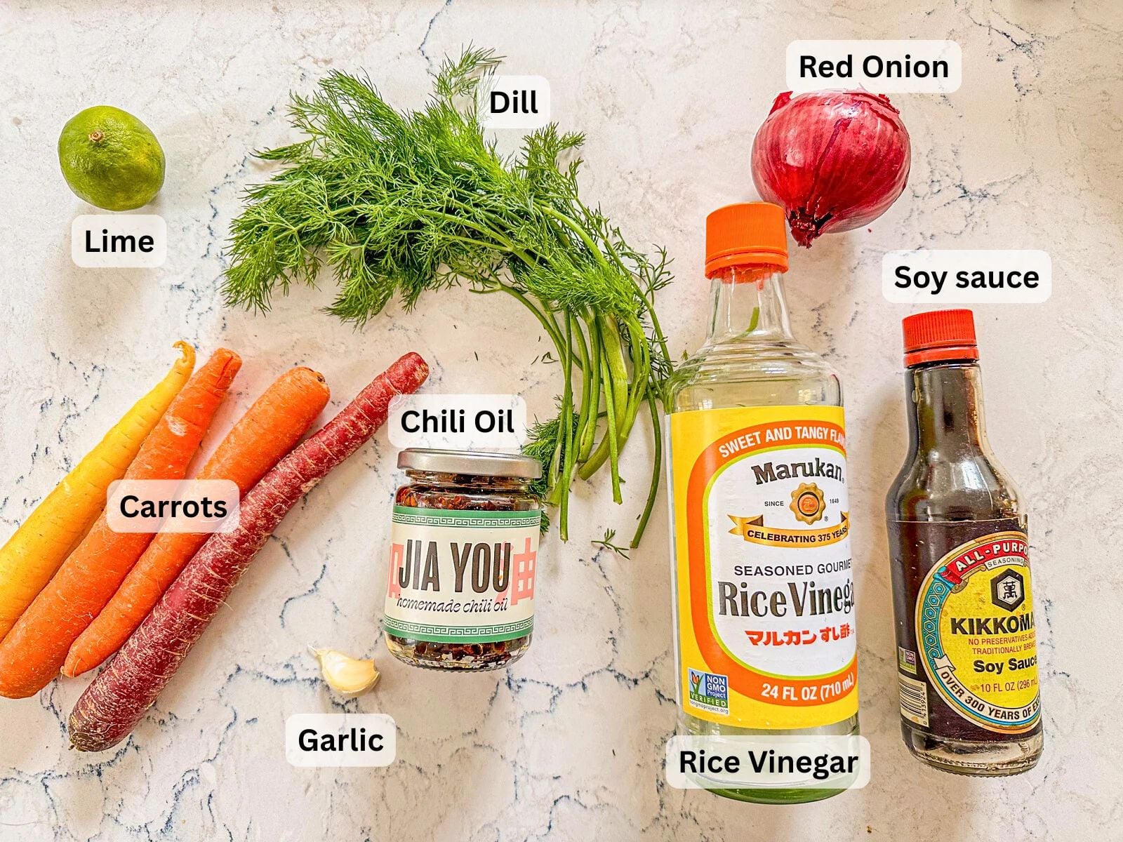 Labeled ingredients for Carrot Salad, including carrots, dill, red onion, lime, garlic, chili oil, rice vinegar, and soy sauce.