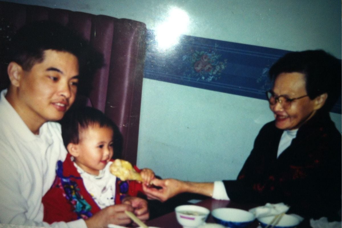 Grandma and father feeding baby a drumstick.