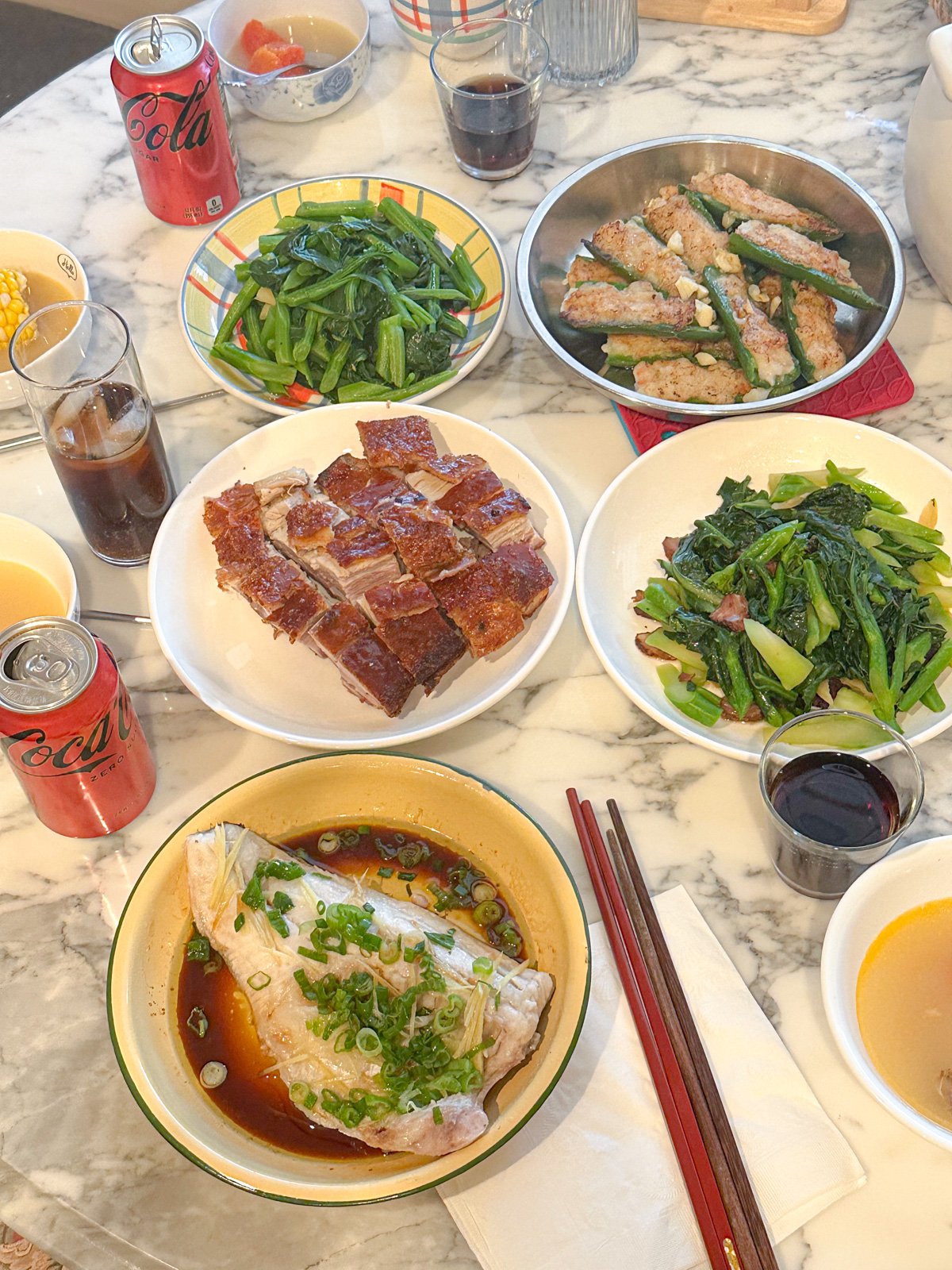 Chinese food spread from sauteed vegetables, roast pork, stuffed jalapenos, steamed fish.