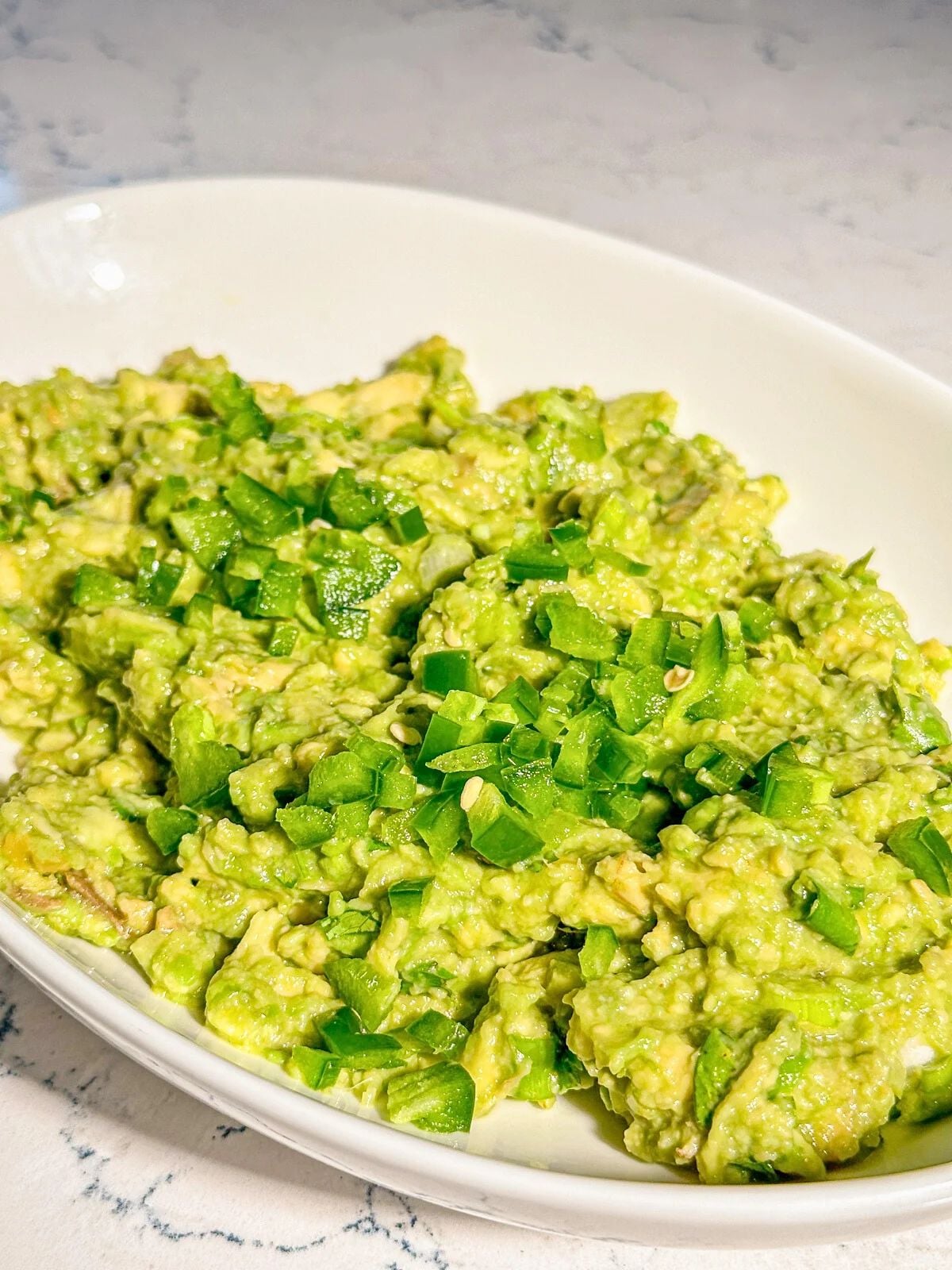 A plate of avocado garnished with green onions.