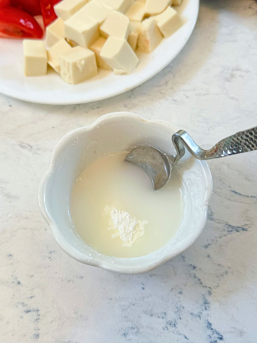 Mixing cornstarch and water in a small saucer.