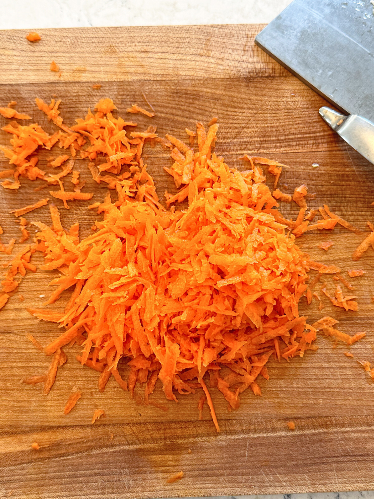 Grated carrots on a chopping board.