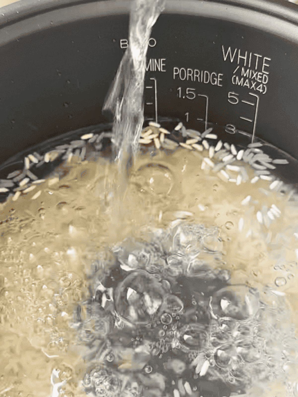 Rice grains soaking in water inside a pot.