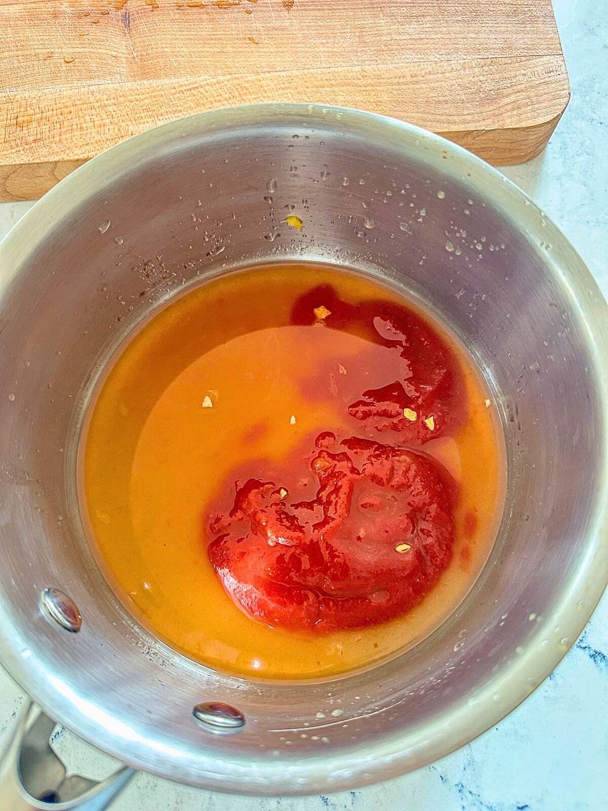 Boiling orange juice with ketchup in a pot. 