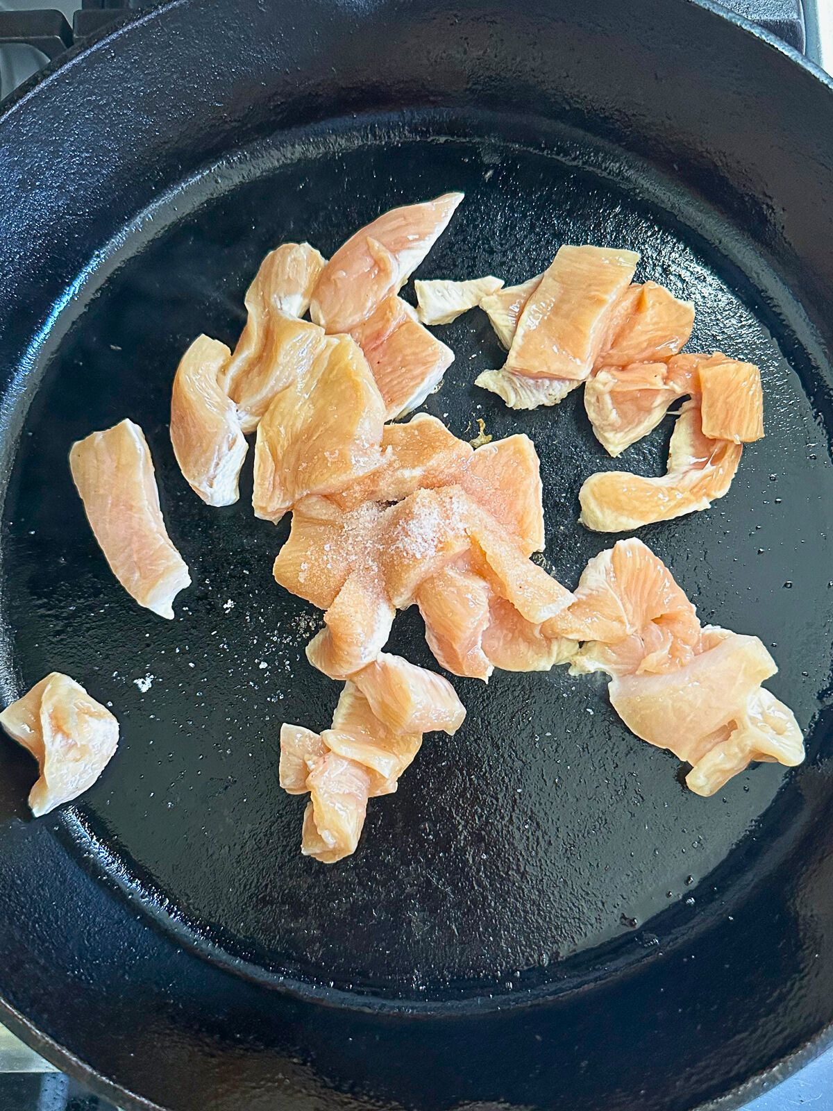 Pieces of chicken breast in a pan.