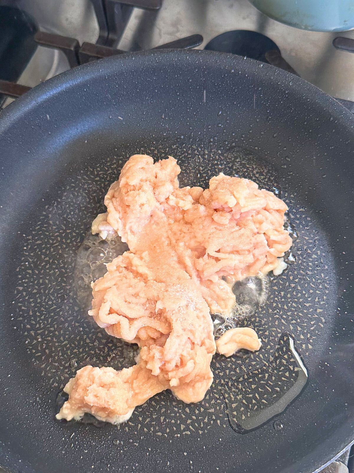 Raw ground meat in a pan.