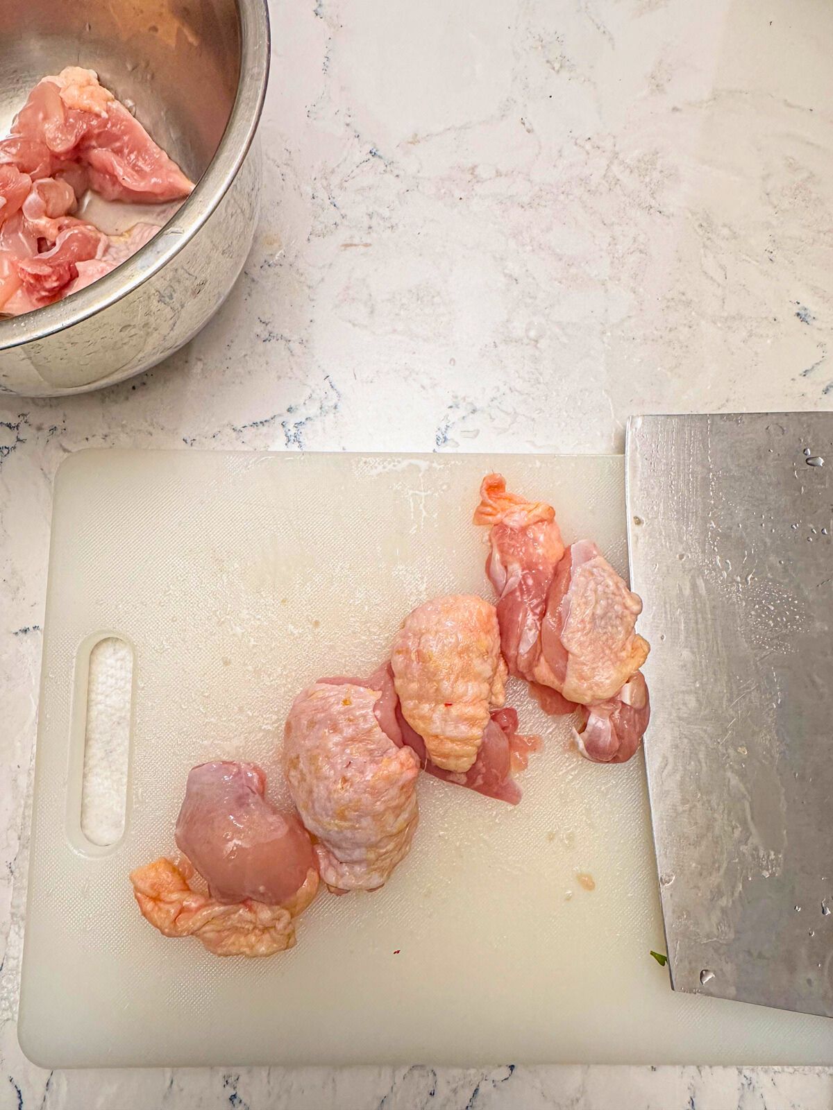 Sliced chicken on a chopping board with a knife.