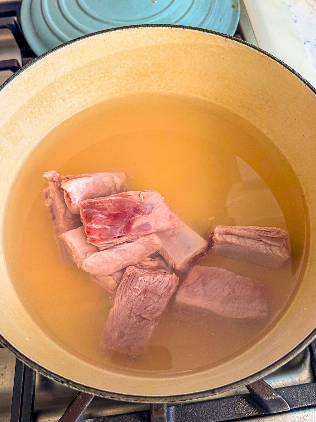 Pork rib chunks in a large pot of water.