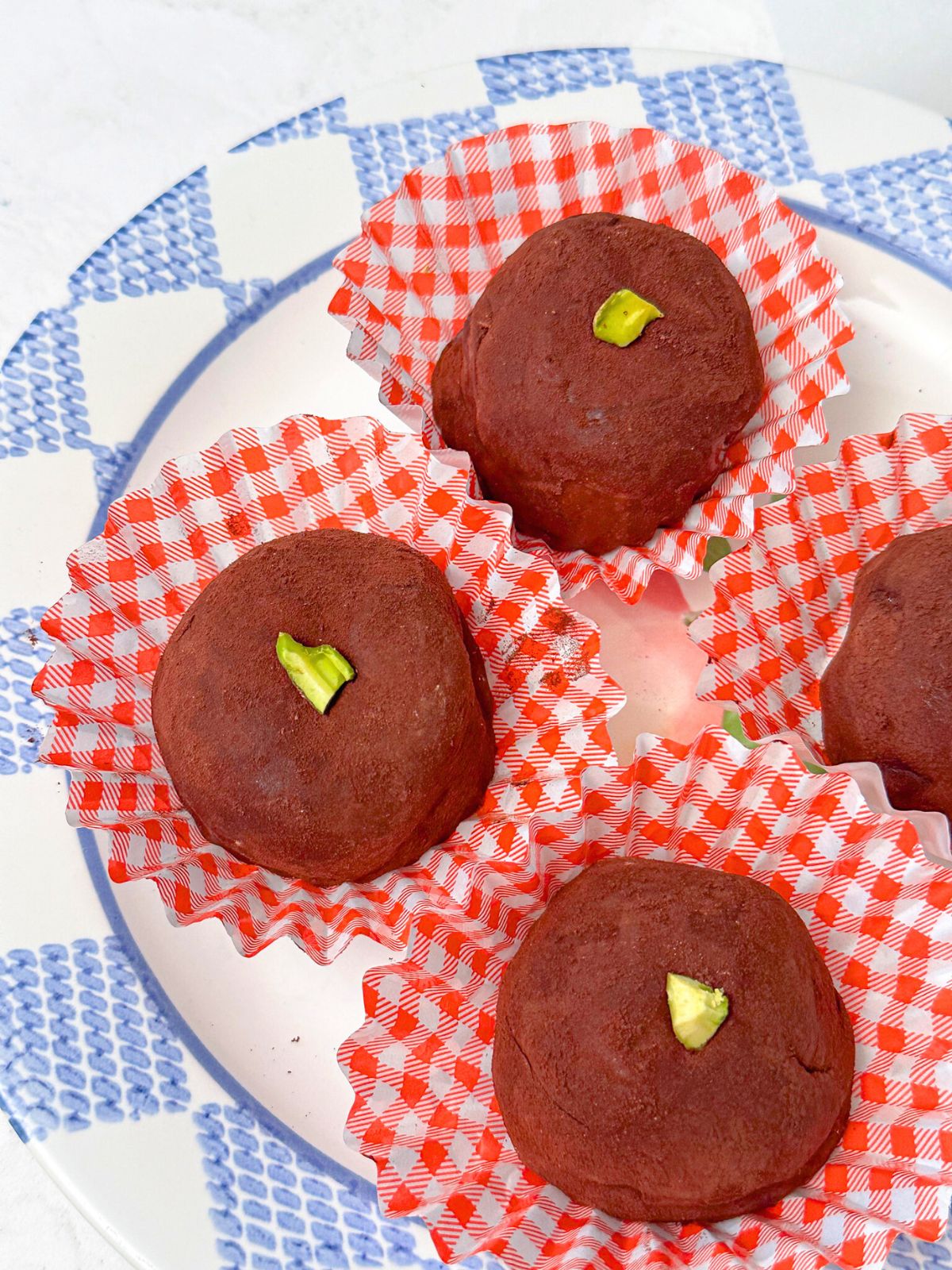 Plate of Korean Dubai chocolate chewy cookies served in red cupcake liners.