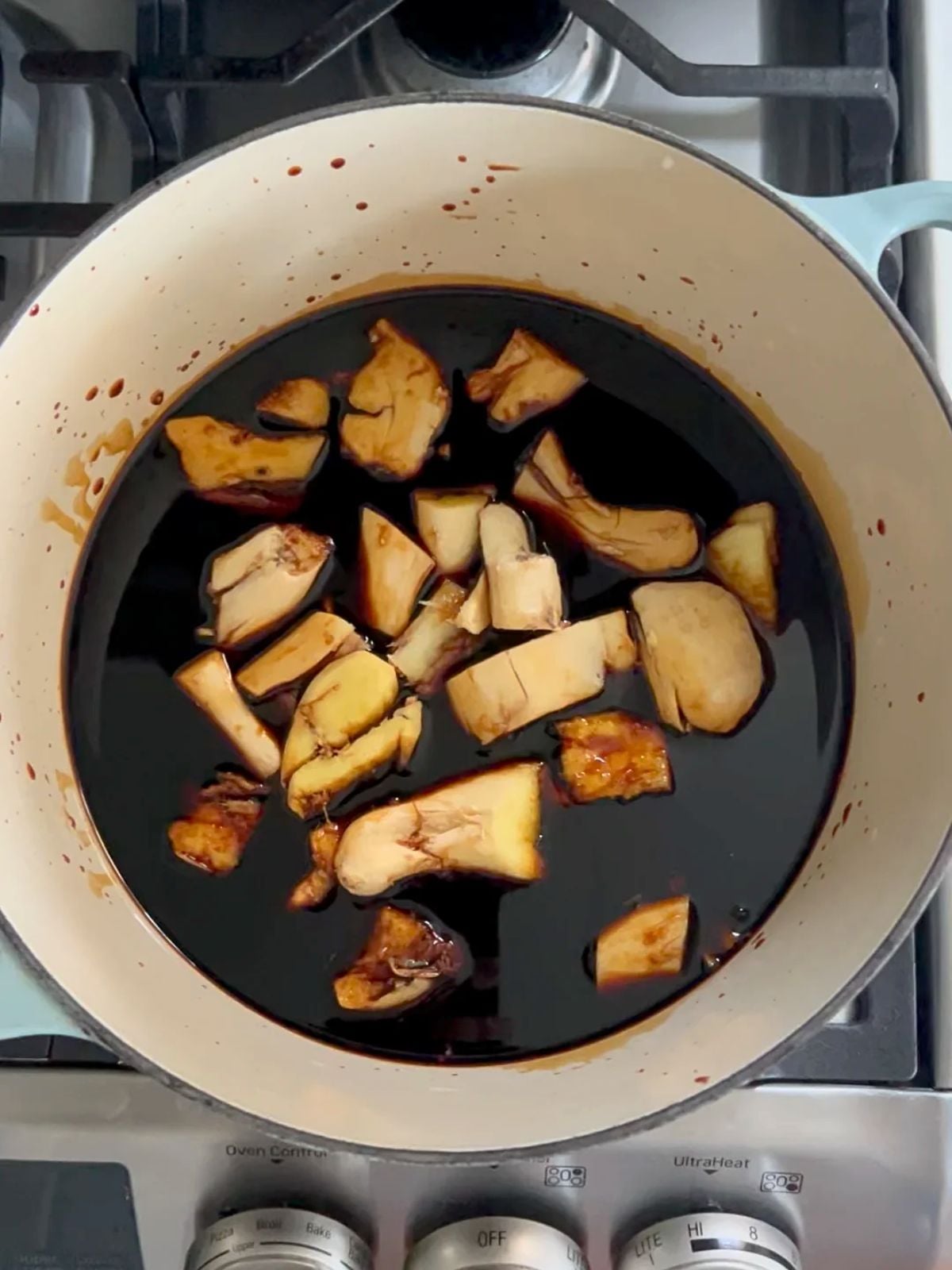 Smashed ginger pieces soaking in Chinese vinegar sauce in a large pot.