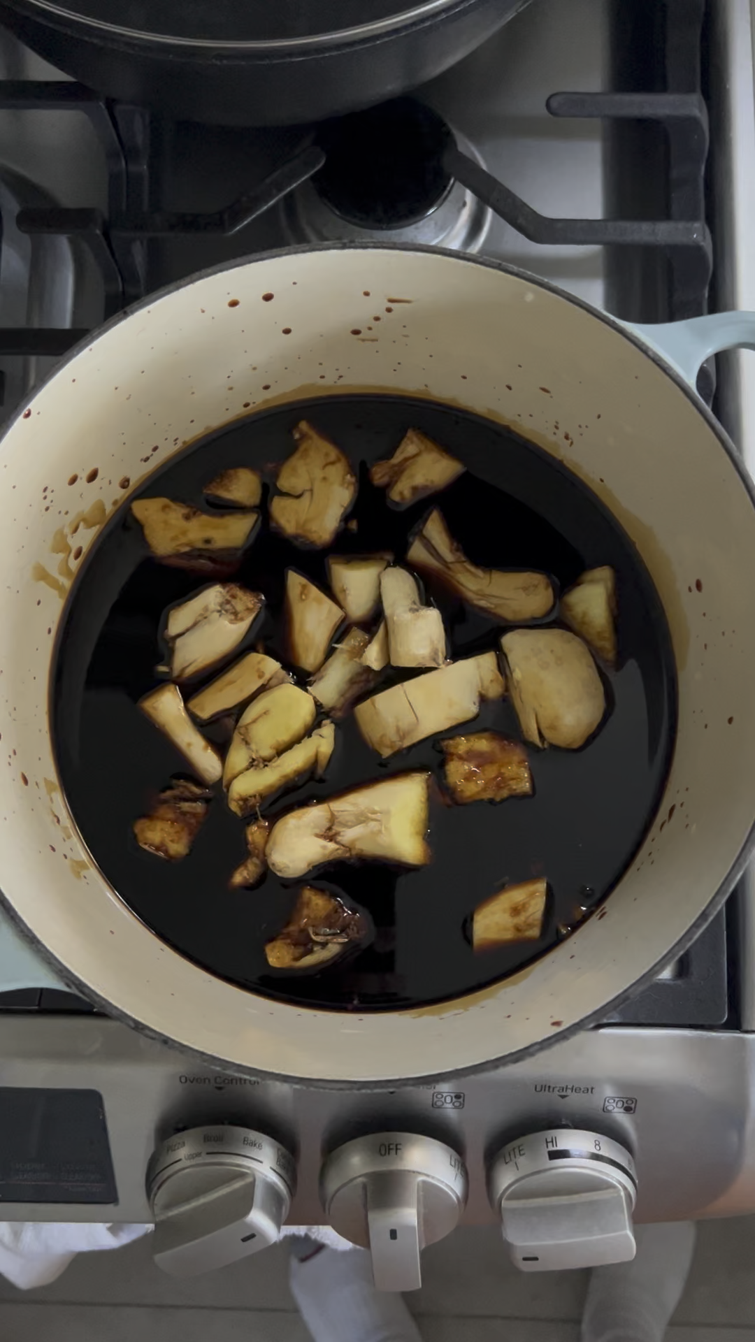 Smashed ginger pieces soaking in Chinese vinegar sauce in a large pot.