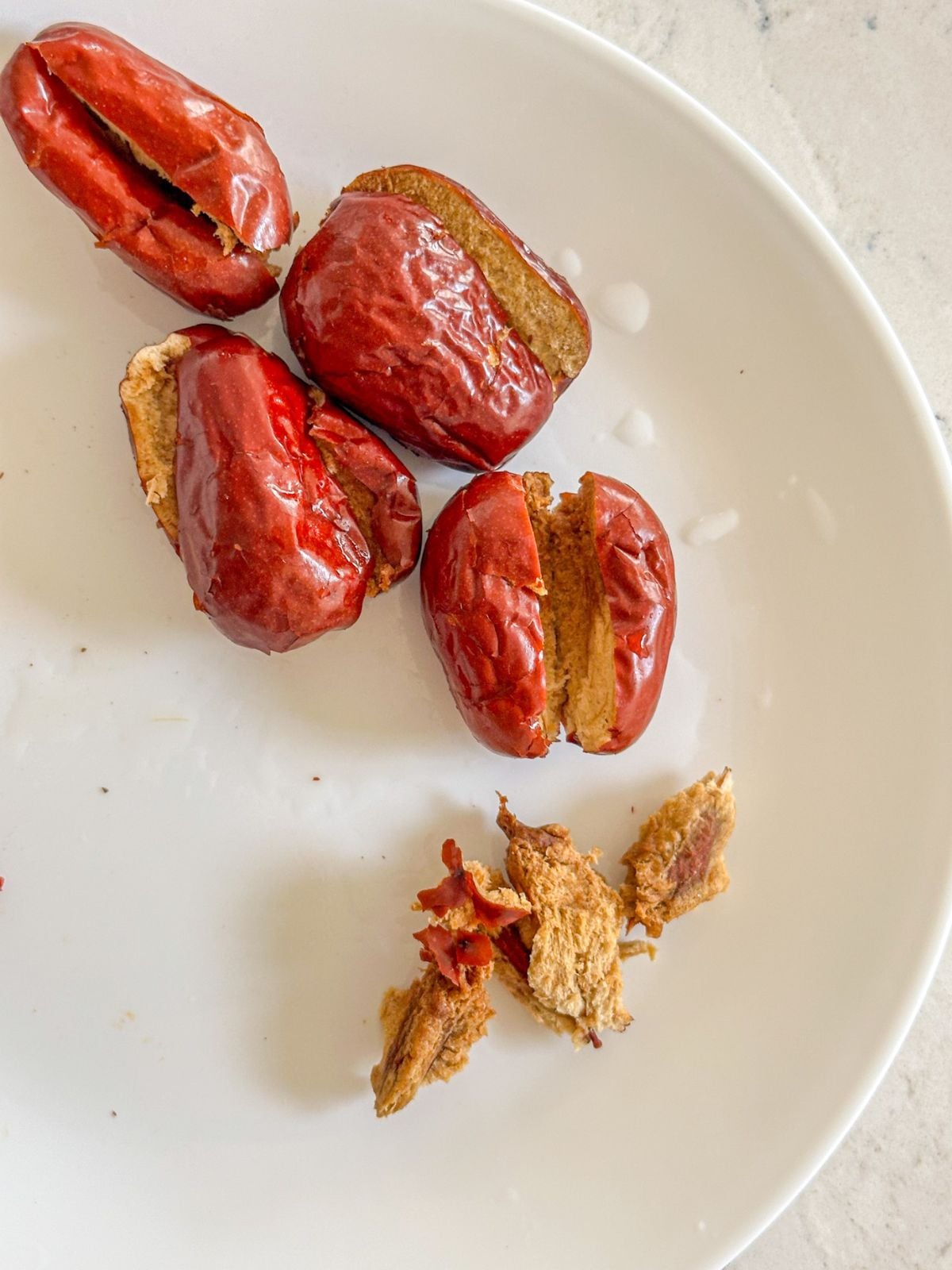 Sliced jujube on a plate with seeds taken out.
