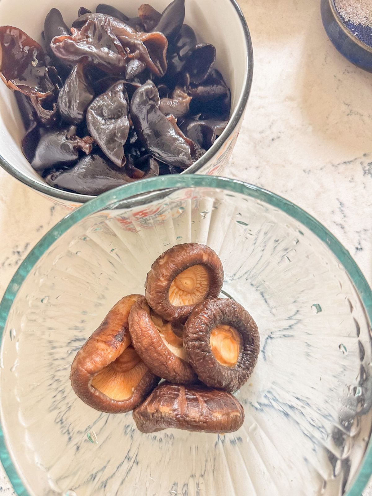 Wood ear mushrooms and shiitake mushrooms in separate bowls.
