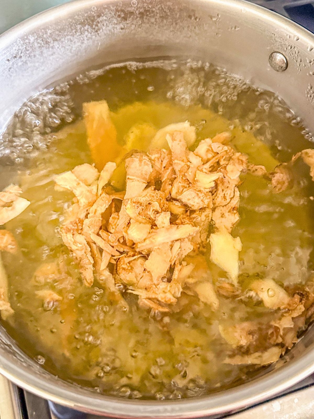 Ginger boiling in a pot of water.
